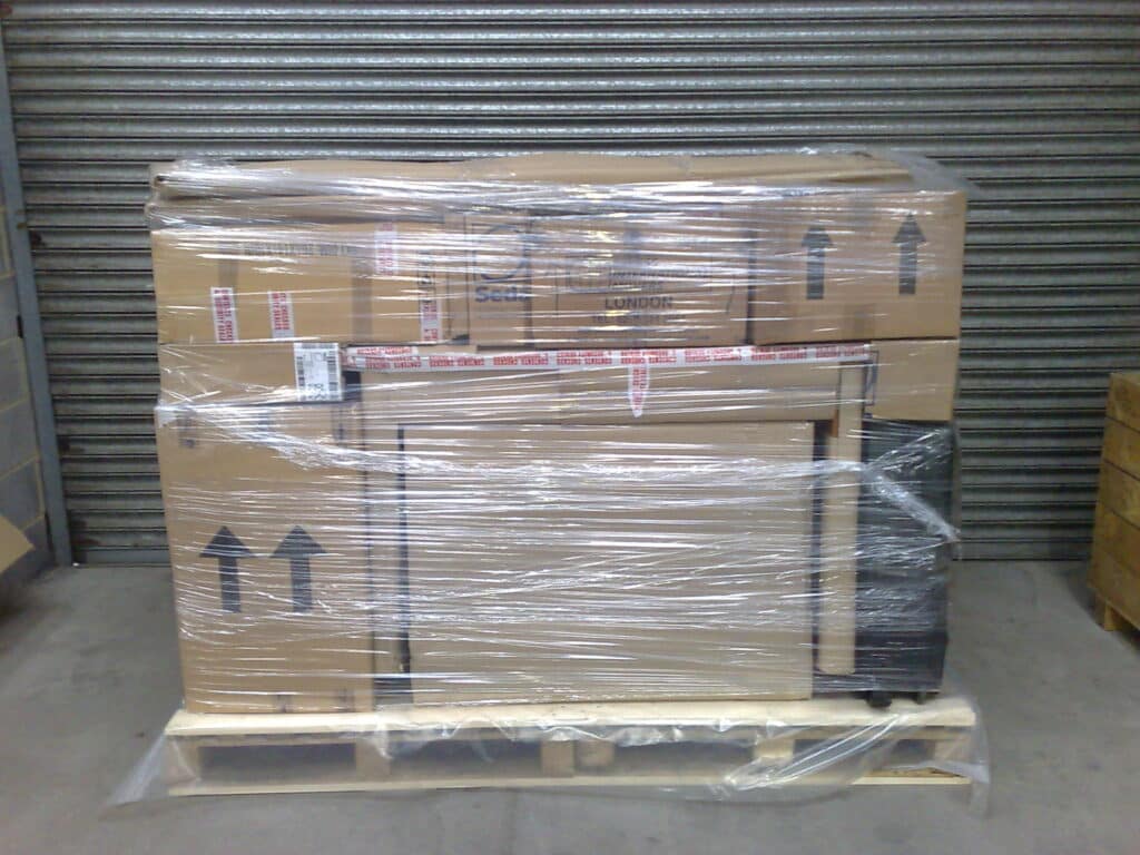 A pallet of furniture & personal belongings carefully arranged onto a pallet, prior to the final stages of packing and shrink wrapping.