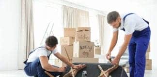 Male movers assembling sofa in new house