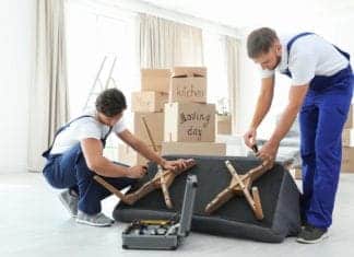 Male movers assembling sofa in new house