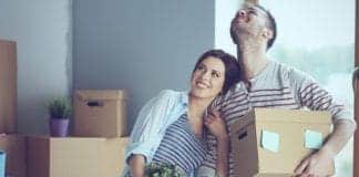 Happy young couple unpacking boxes and moving into a new home.