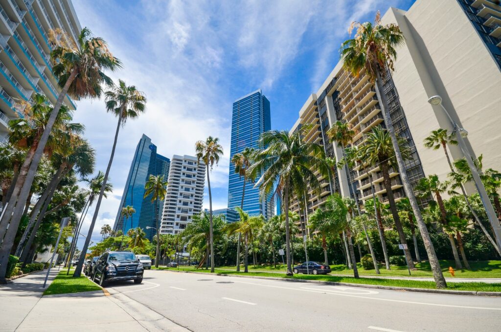 Street-level view of high-rise buildings and palm trees in Brickell, Miami’s financial district known for luxury condos and urban living.