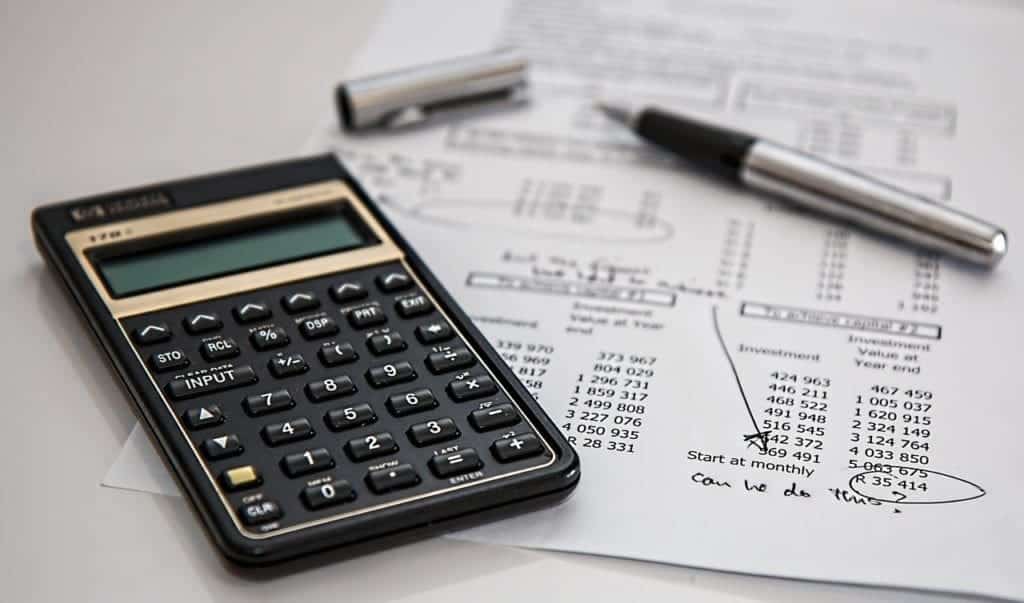 Calculator and financial documents - pros and cons of living abroad