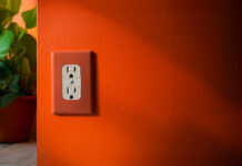 an orange wall with a white Canadian power outlet