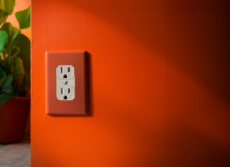 an orange wall with a white Canadian power outlet