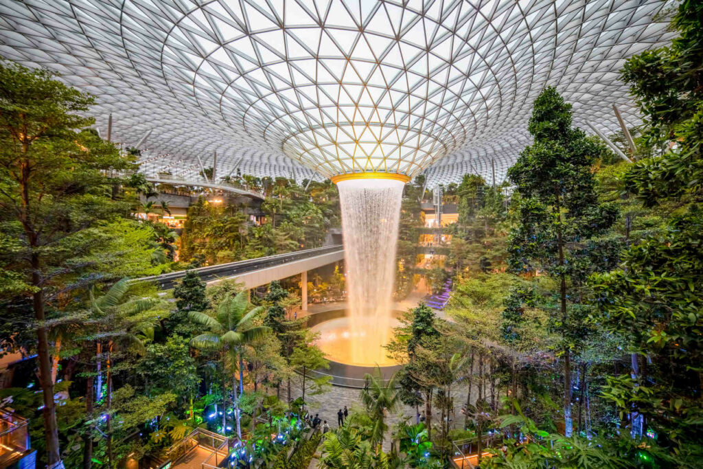 Indoor waterfall and lush greenery at Jewel Changi Airport in Singapore, showcasing the city’s blend of nature and modern architecture.