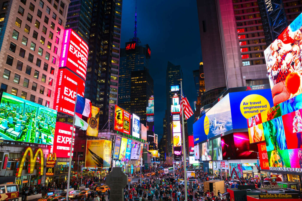 View of illuminated billboards on a busy night in Times Square, New York