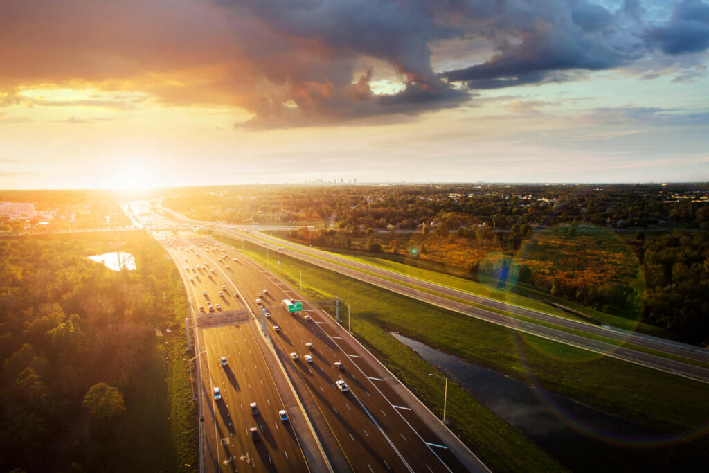 Aerial view of a busy highway in Orlando, Florida, at sunset, highlighting the city’s car-centric transport infrastructure.